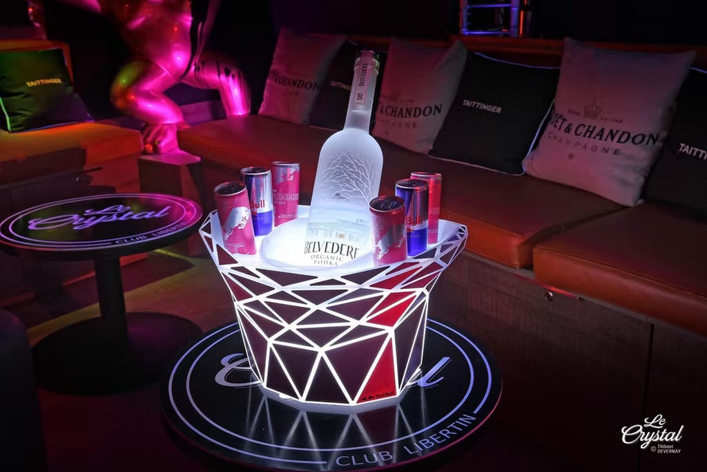 Schwarze Leder-Riemen hängen an einer Wandtafel neben farbiger Neonbeleuchtung im Clubbereich von Le Crystal.