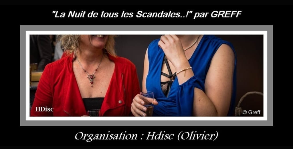 Foto de @HDISC de un momento social de la noche con dos invitados sosteniendo copas de cóctel, vestidos de rojo y azul con joyas, con la leyenda « La noche de todos los escándalos… » y « Organización: HdisC (Olivier). »